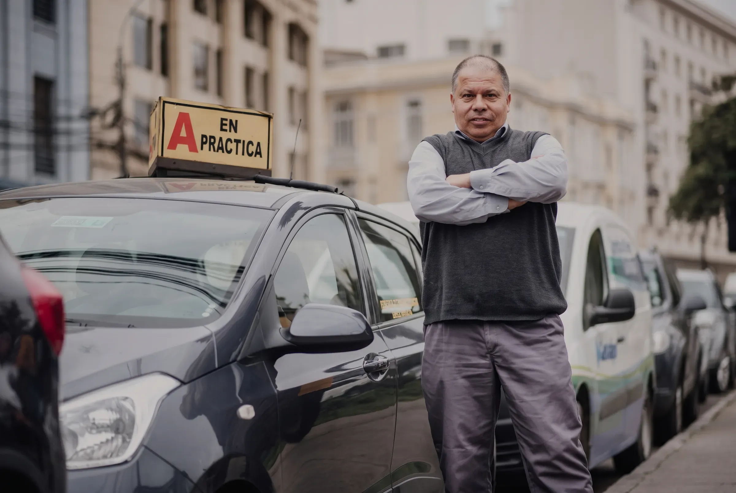 Instructor de la escuela junto al auto con letrero A en práctica