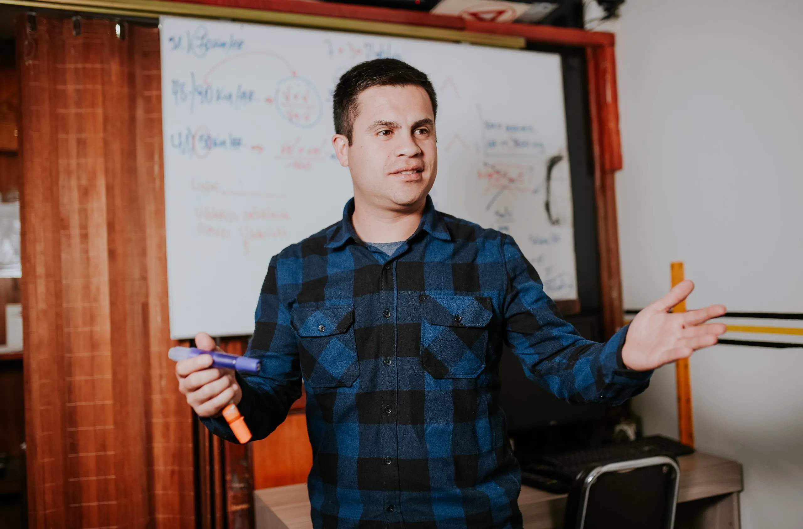Instructor explicando en la pizarra durante una clase teórica